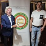 Il titolare Andrea Guglielmetti riceve la vetrofania dell'Accademia dal Delegato Piero Spaini